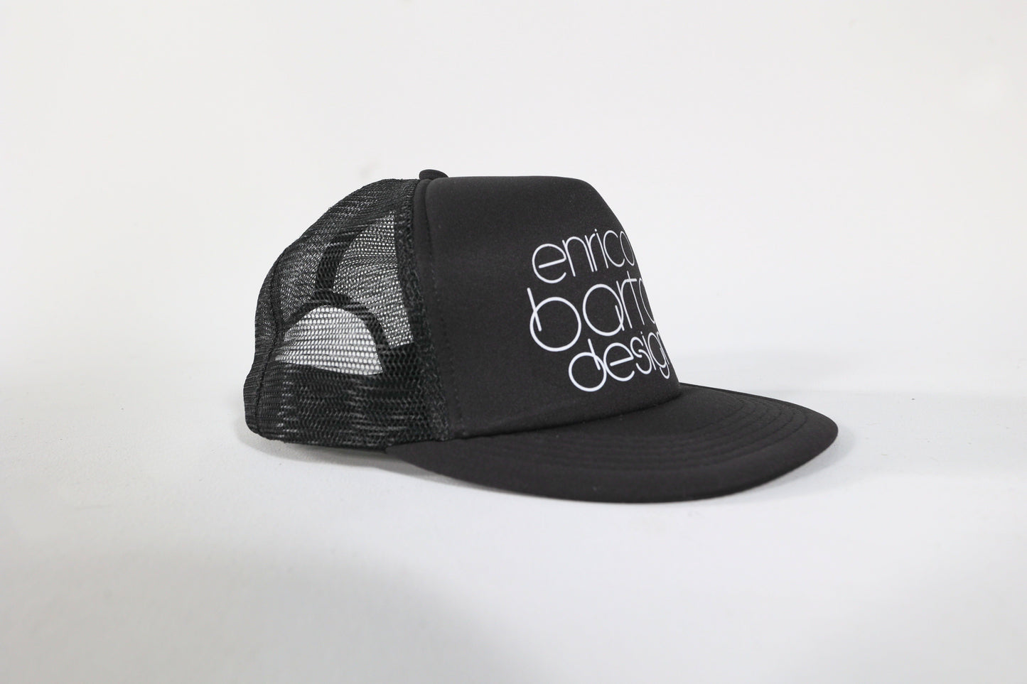 Black cap with 'enrico bartolini design' text on a white background