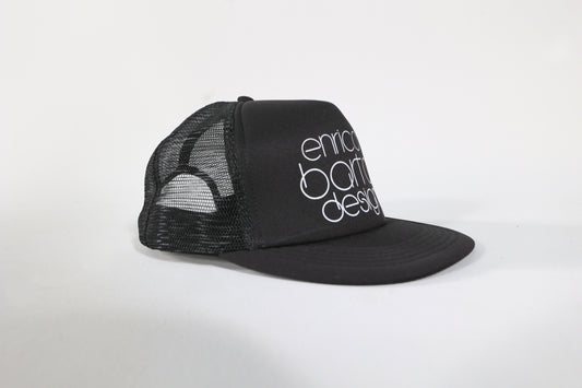 Black cap with 'enrico bartolini design' text on a white background