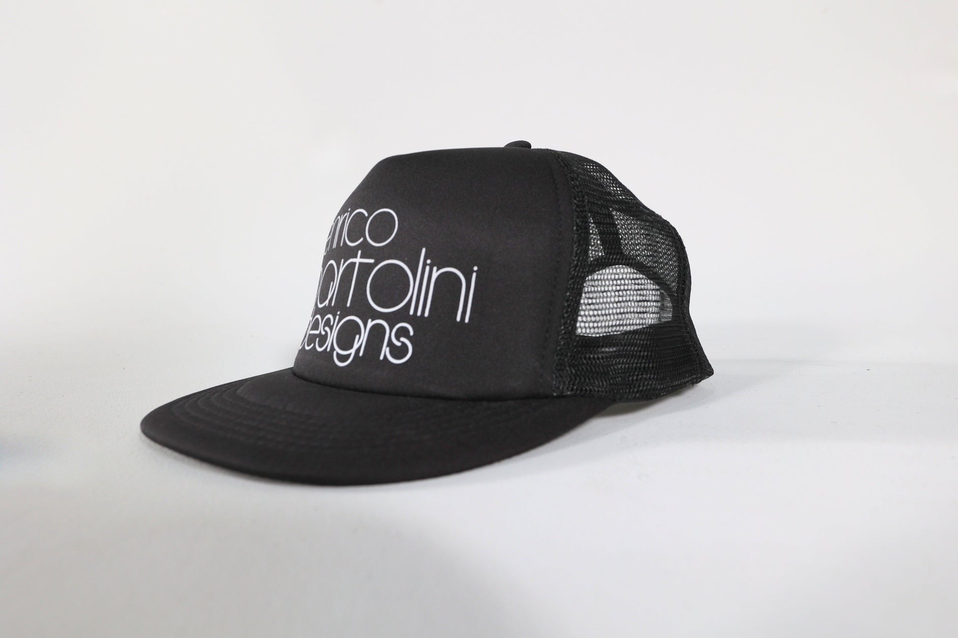 Black trucker cap with white text on a white background