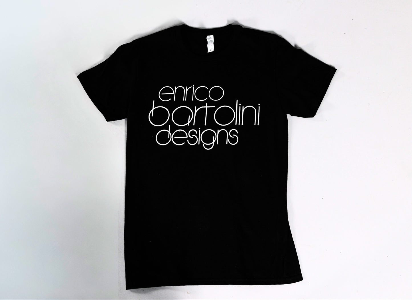Black t-shirt with 'enrico bartolini designs' text on a white background